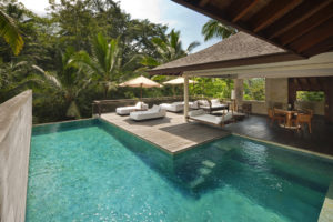 The pool of the 2 bedroom retreat villas Saundarya and Shantivana with view of outdoor terrace and lounge beds