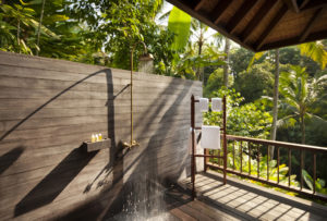 The outdoor shower of the 2 bedroom retreat villas with a towel rail and a view of the Bali jungle in the background