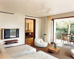 The twin bedroom of the 2 bedroom Saundarya retreat villa with TV inside and open doors leading to a patio with table and chairs