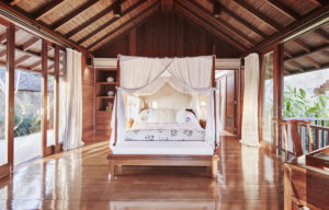 Master bedroom of the Sukma Taru 2 bedroom home with canopy style bed, wooden features and floor to ceiling windows